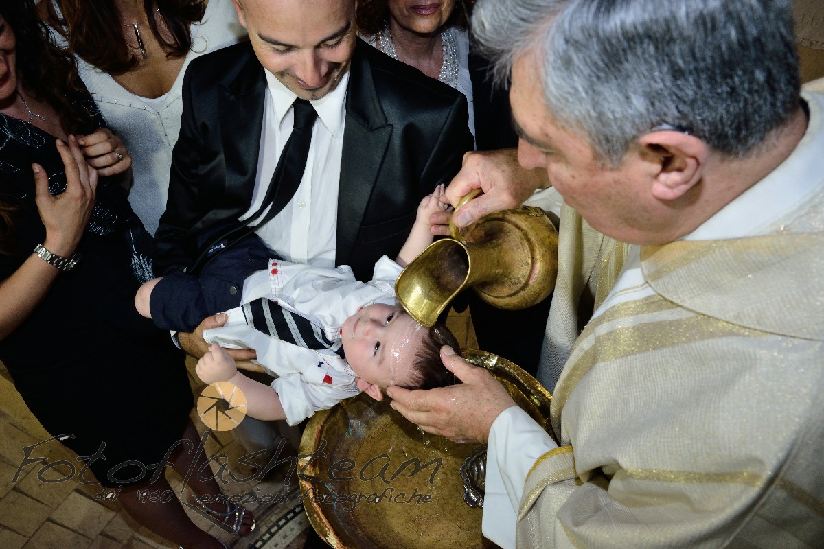 Bambino con papà rito del battesimo acqua battezzando